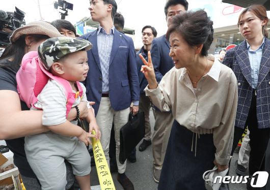 박근혜 전 대통령이 25일 오전 대구 달성군 현풍시장에서 엄마와 함께 시장에 나온 아기와 인사 나누고 있다. 2023.9.25/뉴스1 ⓒ News1 공정식 기자