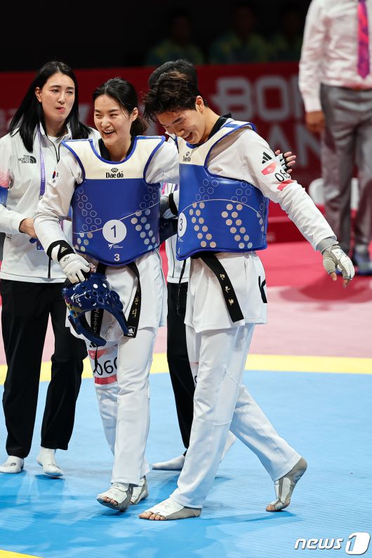 김잔디(왼쪽), 박우혁이 25일 중국 항저우 린안 스포츠문화·전시센터에서 열린 2022 항저우 아시안게임 태권도 겨루기 혼성 단체전 4강 우즈베키스탄과의 경기에서 승리한 후 서로를 격려하고 있다. ⓒ News1 유승관 기자