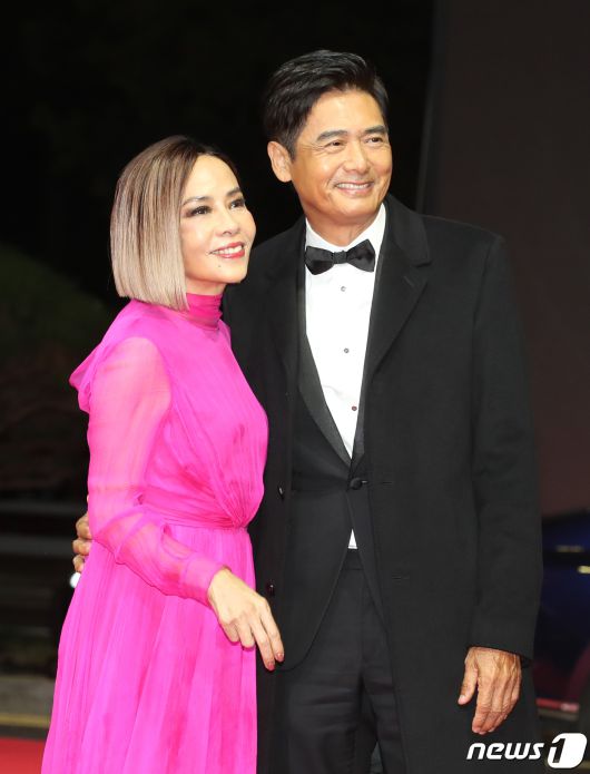 배우 주윤발(저우룬파)이 4일 오후 부산 해운대구 영화의전당에서 열린 ‘제28회 부산국제영화제’(BIFF) 개막식에 아내 진화련과 함께 참석해 인사를 하고 있다. ⓒ News1 권현진 기자