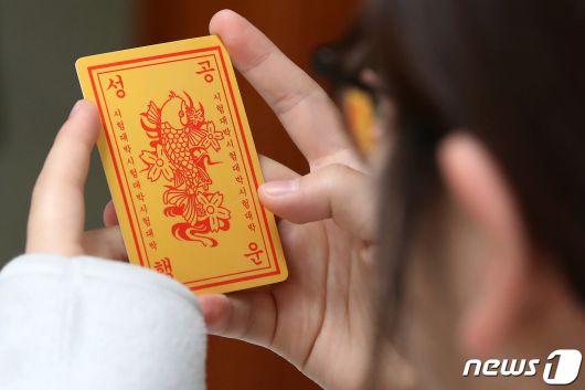 2024학년도 대학수학능력시험을 열흘 앞둔 6일 오전 대구 북구 매천고등학교에서 한 고3 수험생이 미술봉사단 후배들이 직접 만들어 선물한 수능 고득점 부적을 바라보고 있다. 이날 1, 2학년 후배들은 수능 고득점을 기원하는 부적을 비롯해 핫팩과 간식 등 수능 응원 물품을 고3 선배들에게 선물했다. 2023.11.6/뉴스1 ⓒ News1 공정식 기자