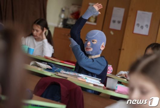 4일(현지시간) 우크라이나 르비우의 한 학교에서 로만(8)이 손을 번쩍 들며 적극적으로 수업에 참여하고 있다. 그는 러시아의 공격으로 몸의 절반 가까이 화상을 입고 30여 차례의 수술을 받았다. 2023.12.04/ ⓒ 로이터=뉴스1 ⓒ News1 권진영 기자