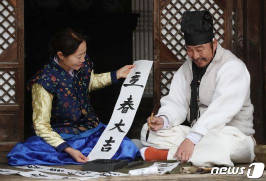 절기상 입춘(立春)을 사흘 앞둔 1일 경기 용인시 기흥구 한국민속촌에서 직원들이 새해의 복을 기원하는 마음을 담아 입춘첩을 쓰고 있다 입춘첩에는 보통 ‘입춘대길(立春大吉) 건양다경(建陽多慶)’(봄이 시작되니 크게 길하고, 경사스러운 일이 많이 생긴다.), ‘소지황금출(掃地黃金出) 개문만복래(開門萬福來)’(땅을 쓸면 황금이 생기고 문을 열면 만복이 온다) 등의 글씨를 써 붙였다. 봄을 기다리는 마음과 한 해 동안의 길한 운과 경사스러움이 가득하기를 기원하는 의미가 담겨있다. 2024.2.1/뉴스1 ⓒ News1 김영운 기자