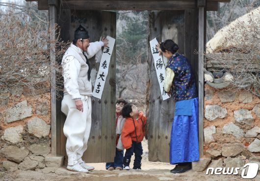 절기상 입춘(立春)을 사흘 앞둔 1일 경기 용인시 기흥구 한국민속촌에서 직원들과 아이들이 입춘대길(立春大吉)과 건양다경(建陽多慶)이라고 적은 입춘첩을 대문에 붙이고 있다. 입춘대길과 건양다경은 '봄이 시작되니 크게 길하고 경사스러운 일이 많이 생기길 기원한다'는 의미를 갖고 있다. 2024.2.1/뉴스1 ⓒ News1 김영운 기자