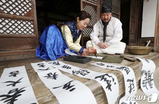 절기상 입춘(立春)을 사흘 앞둔 1일 경기 용인시 기흥구 한국민속촌에서 직원들이 새해의 복을 기원하는 마음을 담아 입춘첩을 쓰고 있다 입춘첩에는 보통 ‘입춘대길(立春大吉) 건양다경(建陽多慶)’(봄이 시작되니 크게 길하고, 경사스러운 일이 많이 생긴다.), ‘소지황금출(掃地黃金出) 개문만복래(開門萬福來)’(땅을 쓸면 황금이 생기고 문을 열면 만복이 온다) 등의 글씨를 써 붙였다. 봄을 기다리는 마음과 한 해 동안의 길한 운과 경사스러움이 가득하기를 기원하는 의미가 담겨있다. 2024.2.1/뉴스1 ⓒ News1 김영운 기자