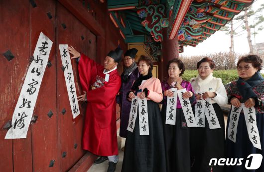 봄의 시작을 알리는 첫번째 절기 입춘(立春)을 사흘 앞둔 1일 부산 동래구 동래향교에서 지역 유림 대표들이 입춘첩을 외삼문에 붙이고 있다. 2024.2.1/뉴스1 ⓒ News1 윤일지 기자