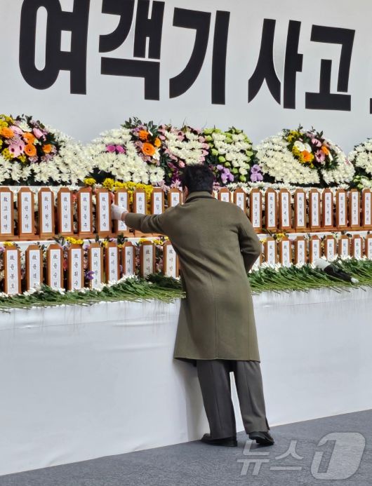 '제주항공 참사' 이튿날인 30일 무안 현지에 마련된 합동 분향소에서 희생자의 고등학교 동창인 이명진 씨(47)가 친구의 위패를 만지며 눈물 흘리고 있다. 2024.12.30/뉴스1