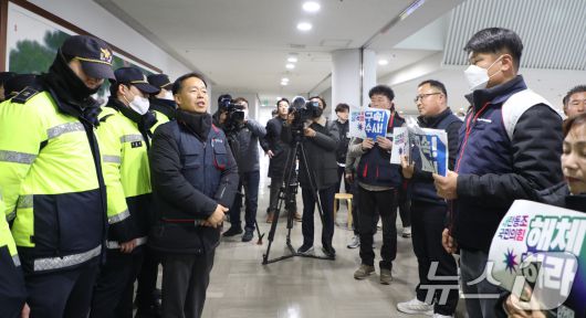 윤석열 대통령이 '12·3 계엄 사태' 이후 43일 만에 체포된 15일 광주시의회 브리핑룸에서 자유민주주의 수호 광주연대가 '탄핵 반대' 기자회견을 개최한 가운데 '탄핵 찬성'을 주장하고 있는 광주비상행동이 회견장 밖에서 구속 수사를 외치고 있다. 2025.1.15/뉴스1 ⓒ News1 이수민 기자