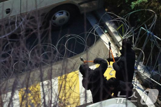 고위공직자범죄수사처(공수처)와 경찰로 구성된 공조수사본부가 윤석열 대통령에 대한 2차 체포영장 집행에 돌입한 15일 오전 공수처 수사관들과 경찰 인력이 서울 용산구 한남동 대통령 관저로 진입하며 철조망을 제거하고 있다. 2025.1.15/뉴스1 ⓒ News1 신웅수 기자
