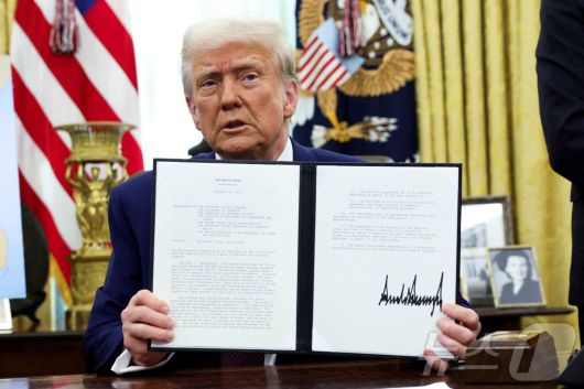 도널드 트럼프 미국 대통령이 지난 2월 13일(현지시간) 미국 워싱턴DC 백악관 오벌 오피스에서 '상호관세'에 관한 메모에 서명한 뒤 이를 들어 보이고 있다. ⓒ 로이터=뉴스1 ⓒ News1 류정민 특파원