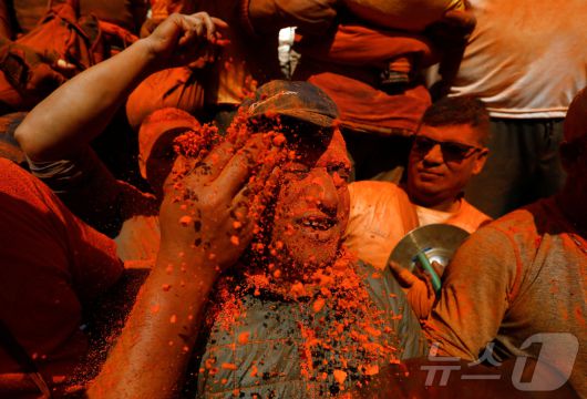 15일(현지시간) 네팔 박타푸르에서 열린 신두르 자트라 축제에서 시민들이 주홍 가루를 얼굴에 바르고 있다. ⓒ 로이터=뉴스1