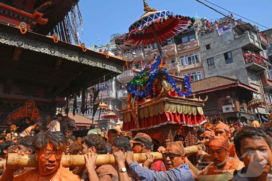 15일(현지시간) 네팔 카트만두에서 열린 신두르 자트라 축제에서 시민들이 신을 모신 가마를 이동하며 축제를 즐기고 있다. ⓒ AFP=뉴스1