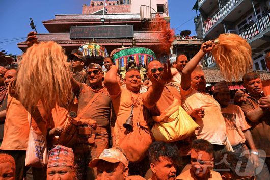 15일(현지시간) 네팔 카트만두에서 열린 신두르 자트라 축제에서 시민들이 주홍 가루를 뿌리며 축제를 즐기고 있다. ⓒ AFP=뉴스1