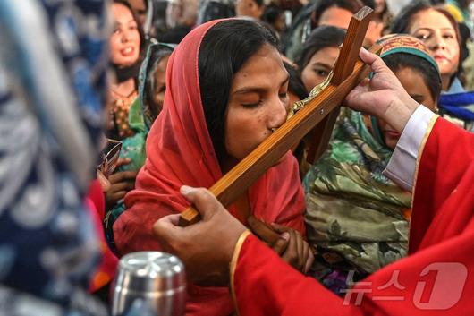 18일(현지시간) 파키스탄 라호르 성 안토니우스 교회에서 열린 성금요일 예배에서 한 기독교 신자가 예수 그리스도의 십자가 처형 장면을 묘사하는 키스를 하고 있다. ⓒ AFP=뉴스1