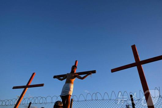 18일(현지시간) 아르헨티나 부에노스아이레스에서 열린 성금요일 행사에서 십자가에 못 박힌 예수의 모습을 재연하고 있다. ⓒ AFP=뉴스1