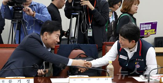 류기정 최저임금위원회 사용자위원과 이미선 근로자위원이 22일 오후 세종시 어진동 정부세종청사 고용노동부에서 열린 2026년 최저임금위원회 제1차 전원회의에 참석하며 악수를 나누고 있다. 2025.4.22/뉴스1 ⓒ News1 김기남 기자