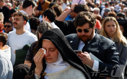 23일(현지시간) 바티칸 성 베드로 광장에서 한 수녀가 프란치스코 교황이 성 베드로 대성당으로 옮겨지자 눈물을 흘리고 있다. ⓒ 로이터=뉴스1 ⓒ News1