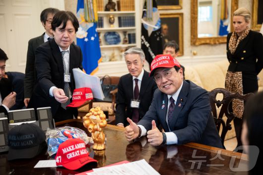 지난 16일(현지시간) 미국 워싱턴DC 백악관 집무실을 찾은 아카자와 료세이 일본 경제재생상이 도널드 트럼프 미국 대통령이 서명해 건네 준 '마가(MAGA, 미국을 다시 위대하게' 모자를 써보고 있다.(출처 백악관) ⓒ News1 류정민 특파원