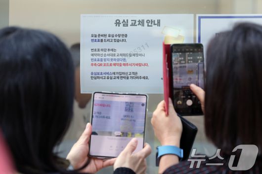 해킹 공격으로 가입자 유심 정보가 탈취된 SK텔레콤이 가입자 유심 무상 교체를 시작한 28일 오전 서울 종로구 T월드 직영매장 앞에서 번호표를 받지 못한 고객들이 온라인 예약을 하고 있다.  2025.4.28/뉴스1 ⓒ News1 박정호 기자