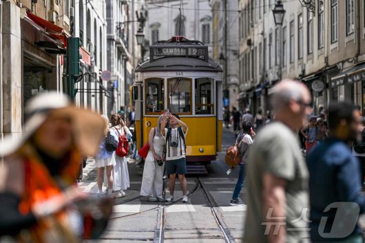 이베리아 반도에 대규모 정전이 발생한 28일(현지시간) 포르투갈 리스본 시내 거리에서 정전으로 정지된 트램 앞에서 시민들이 기념촬영을 하고 있다. ⓒ AFP=뉴스1
