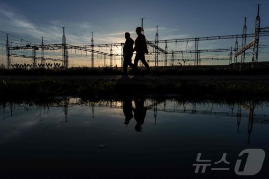 이베리아 반도에 대규모 정전이 발생한 28일(현지시간) 스페인 부르고스의 변전소 앞을 시민들이 지나가고 있다. ⓒ AFP=뉴스1