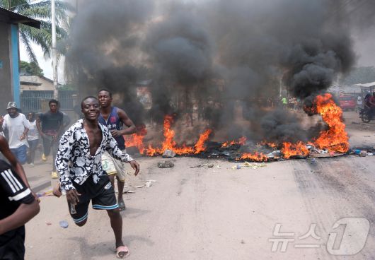 28일(현지시간) 콩고민주공화국 킨샤사에서 일어난 시위 도중 타이어 등이 불에 타고 있다. ⓒ 로이터=뉴스1 ⓒ News1 류정민 특파원
