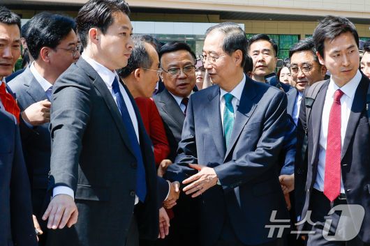 한덕수 전 국무총리가 2일 오전 서울 여의도 국회 소통관에서 '국민께 드리는 약속'을 주제로 제21대 대통령 선거 출마를 선언한 뒤 추경호 국민의힘 의원과 악수하고 있다. 2025.5.2/뉴스1 ⓒ News1 안은나 기자