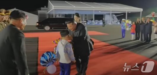 지난달 25일 열린 5000t급 신형 구축함 '최현호' 진수 기념식에서 김정은 총비서가 어린 아이의 볼을 맞잡고 있다 (조선중앙tv 화면 갈무리)