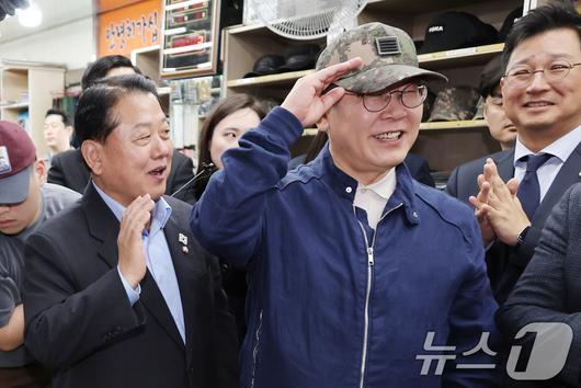 '골목골목 경청투어 : 접경벨트편'에 나선 이재명 더불어민주당 대통령 후보가 2일 오후 강원 화천군 화천공영버스터미널 인근에 위치한 군장점에서 김병준 최고위원이 구입한 병장 계급장이 달린 육군 모자를 착용하고 있다. (공동취재) 2025.5.2/뉴스1 ⓒ News1 이재명 기자