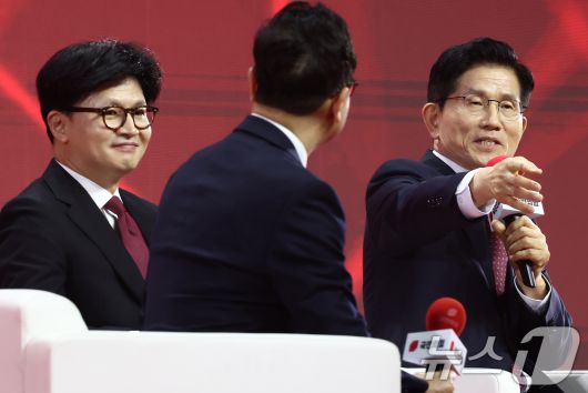 김문수 국민의힘 대선 경선 후보 3일 오후 경기 고양시 킨텍스에서 열린 제5차 전당대회에서 제21대 대통령선거 최종 후보 선출을 위한 개표 결과를 기다리며 아내 설난영 여사를 가리키며 소개하고 있다. 왼쪽은 한동훈 후보. 2025.5.3/뉴스1 ⓒ News1 김민지 기자