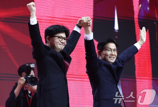 국민의힘 김문수, 한동훈 대선 경선 후보가 3일 경기 고양시 킨텍스에서 열린 5차 전당대회에서 손을 맞잡고 기념촬영을 하고 있다. 2025.5.3/뉴스1 ⓒ News1 김민지 기자