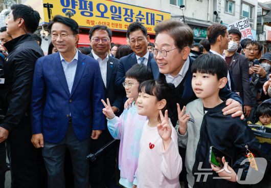 이재명 더불어민주당 대통령 후보가 2차 골목골목 경청투어에 나선 5일 오후 경기 양평군 양평시장의 문구점 앞에서 어린이들과 기념 촬영하고 있다. 2025.5.5/뉴스1 ⓒ News1 안은나 기자