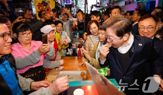 이재명 더불어민주당 대통령 후보가 2차 골목골목 경청투어에 나선 5일 오후 충북 음성군 무극시장을 찾아 꽈배기를 시식하고 있다. 2025.5.5/뉴스1 ⓒ News1 안은나 기자