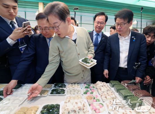 이재명 더불어민주당 대통령 후보가 골목골목 경청투어 이틀차를 맞은 6일 오전 충북 증평군 장뜰시장의 떡집을 찾아 떡을 고르고 있다. (공동취재) 2025.5.6/뉴스1 ⓒ News1 안은나 기자