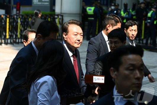 윤석열 전 대통령이 12일 오전 서울 서초구 중앙지방법원에서 열린 내란 우두머리 혐의, 직권남용 권리행사방해 혐의 사건 3차 공판에 출석, 취재진의 질문을 받으며 이동하고 있다. 2025.5.12/뉴스1 ⓒ News1 사진공동취재단