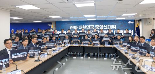 박찬대 더불어민주당 대표 직무대행 겸 원내대표가 지난 8일 서울 여의도 더불어민주당 중앙당사에서 열린 후보직속 '글로벌책임강국위원회 대책회의'에서 조정식, 이종석 공동위원장을 비롯한 참석자들과 함께 구호를 외치고 있다. 2025.5.8/뉴스1 ⓒ News1 이승배 기자