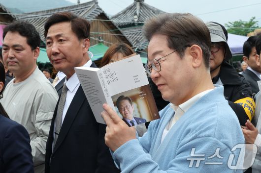 이재명 더불어민주당 대통령 후보가 15일 오전 경남 하동군 화개장터 입구에서 유튜브 K-이니셔TV 케미폭발 '동서화합' 화개장터 라이브 오프닝을 마치고 이동하던 중 지지자들에게 사인을 해주고 있다. 2025.5.15/뉴스1 ⓒ News1 안은나 기자