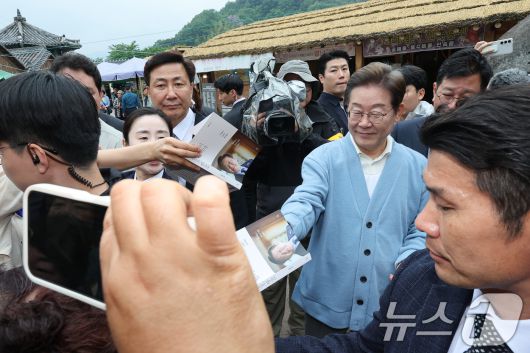 이재명 더불어민주당 대통령 후보가 15일 오전 경남 하동군 화개장터 입구에서 유튜브 K-이니셔TV 케미폭발 '동서화합' 화개장터 라이브 오프닝을 마치고 이동하던 중 지지자들에게 사인해주고 있다. 2025.5.15/뉴스1 ⓒ News1 안은나 기자