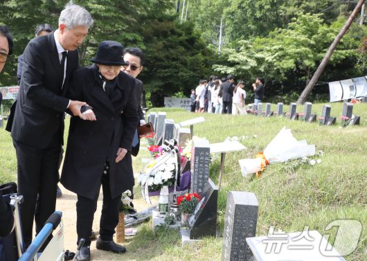 노태우 전 대통령의 아내 김옥숙씨가 19일 광주 북구 망월동 민족민주열사묘역(구묘역)에 참배하고 있다. 아들인 노재헌 재단법인 동아시아문화센터 이사장이  부축하고 있다. 2025.5.19/뉴스1 ⓒ News1 이수민 기자