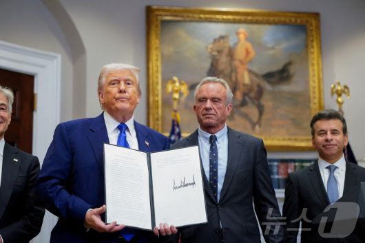도널드 트럼프 미국 대통령이 12일(현지시간) 워싱턴 백악관에서 처방 약값 인하 행정 명령을 로버트 케네디 주니어 보건복지 장관과 들고 있다. 2025.05.13 ⓒ 로이터=뉴스1 ⓒ News1 우동명 기자