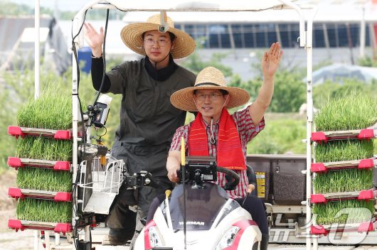 김문수 국민의힘 대통령 후보가 21일 경기 고양시 한 논에서 청년 농업인과 이앙기를 타고 손을 흔들고 있다. 2025.5.21/뉴스1 ⓒ News1 김민지 기자