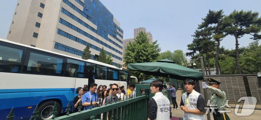 톈진 거주 교민들이 재외투표 첫날인 20일 대사관에서 마련한 셔틀버스에서 내려 주중대사관으로 들어가고 있다. ⓒ News1 정은지 특파원