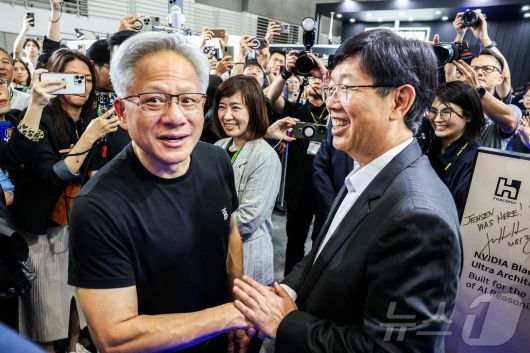 젠슨 황 엔비디아 CEO가 20일 (현지시간) 타이베이 난강 전시관에서 열린 '컴퓨텍스 2025'에 도착해 류양웨이 폭스콘 회장과 악수를 하고 있다. 2025.05.21 ⓒ AFP=뉴스1 ⓒ News1 우동명 기자