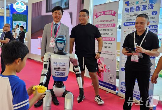 최이돈 원장이 23일 중국 하문에서 열린 WESAVC 전시장에서 인공지능 로봇을 보고 있다. ⓒ 뉴스1