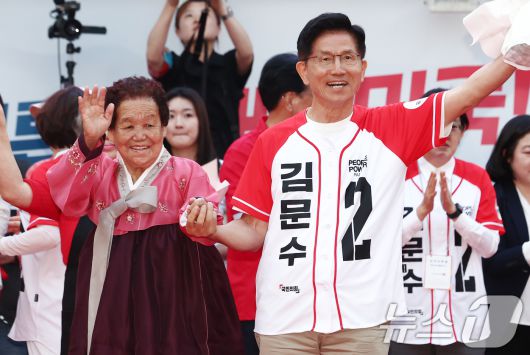 김문수 국민의힘 대통령 후보가 31일 경북 포항시 북포항우체국 인근에서 열린 집중유세에서 어르신과 사진을 찍고 있다. 2025.5.31/뉴스1 ⓒ News1 김민지 기자