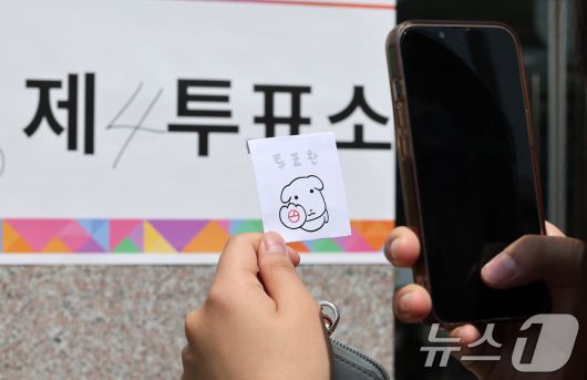 제21대 대통령 선거일인 3일 서울 서대문구 서울창서초등학교에 마련된 신천동 제5투표소를 찾은 유권자가 투표를 마친 후 인증샷을 찍고 있다. 2025.6.3/뉴스1 ⓒ News1 김성진 기자