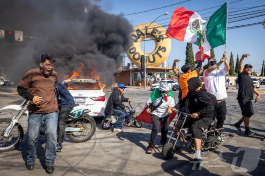 미국 이민세관단속국(ICE)이 7일(현지시간) 캘리포니아주 로스앤젤레스 카운티의 파라마운트에서 불법 체류자 단속에 나선 후 시위가 격화되고 있는 가운데 시위대들이 교차로에 모여 있다. 2025.6.7./뉴스1 ⓒ 로이터=뉴스1 ⓒ News1 이창규 기자