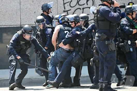 8일(현지시간) 미국 캘리포니아주 로스앤젤레스 시내 메트로폴리탄 구치소 MDC 밖에서 경찰 및 관계자들이 시위대와 충돌하고 있다. ⓒ AFP=뉴스1 ⓒ News1 김성진 기자