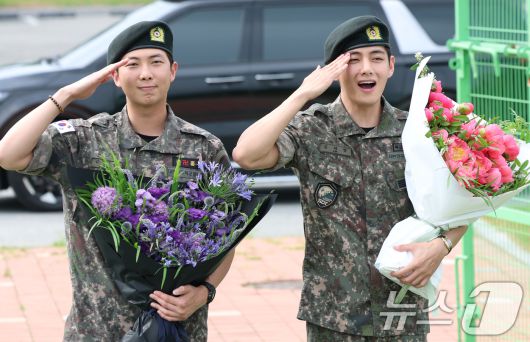 방탄소년단(BTS)의 RM(김남준, 30)과 뷔(김태형, 29)가 10일 오전 강원도 춘천시 신북읍 체육공원 축구장에서 군 복무를 마친 뒤 전역 인사를 하고 있다. ⓒ News1 권현진 기자