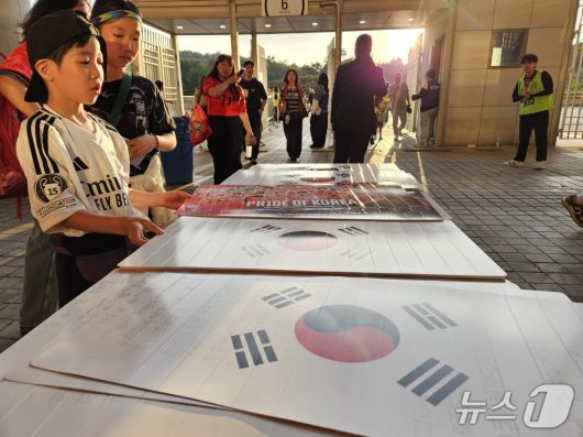 한국-쿠웨이트전에 입장하는 팬들이 태극기 클래퍼를 받아들고 있다. ⓒ News1 안영준 기자