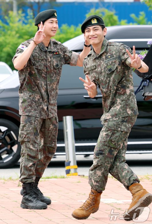 방탄소년단(BTS)의 RM(김남준, 30)과 뷔(김태형, 29)가 10일 오전 강원도 춘천시 신북읍 체육공원 축구장에서 군 복무를 마친 뒤 브이를 그리며 인사를 하고 있다. ⓒ News1 권현진 기자